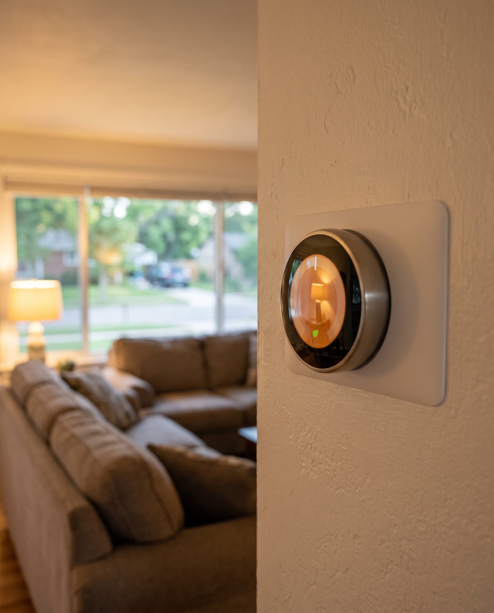 A smart thermostat on a living room wall